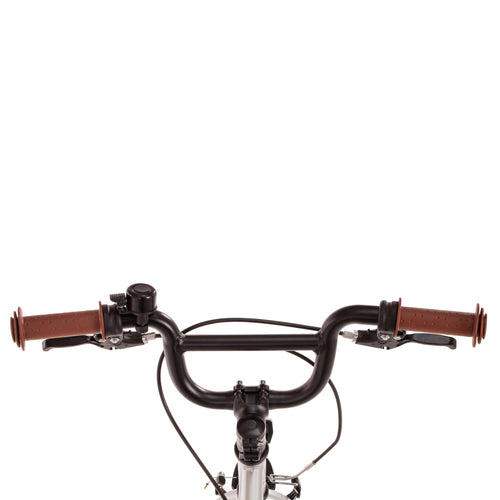 Kinderfahrrad mit Retro-Vibes: ein Stahlrahmen in glänzendem SIlber mit braunen Applikationen wie Sattel, Griffe und Reifen. 